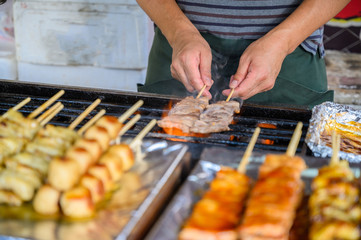 Traditional some meat skewers being grilled in a barbecue, in Japan at street food vendor market, grilled satay. Japanese Food.