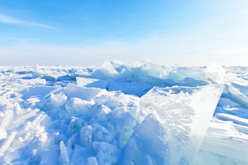 Fototapeta na wymiar Snow covered ice hummocks on Lake Baikal on a frosty sunny day in January. Natural cold background
