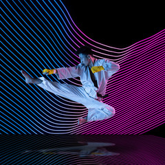 Creative sport on dark neon lighted line background. Hand-combat, training in action and motion on...