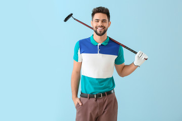 Handsome male golfer on color background