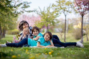Fototapeta premium Grandmother and children in a beautiful blooming spring park
