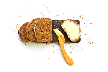 Slice of organic bread with butter on wooden cutting board