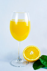 glass of orange juice, orange and orange leaves, on bright background