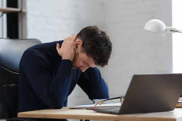 Tired architect working overtime in office. Stressed businessman have financial problems and searching ideas to overcome financial crisis. Entrepreneur in bankruptcy. Burnout and overwork concept.