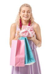 Beautiful young woman with gift and shopping bags on white background. International Women's Day celebration