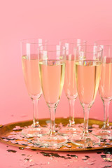 Glasses of tasty champagne on color background