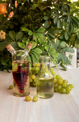 Bottles of wine and a bunch of grapes on a table close-up