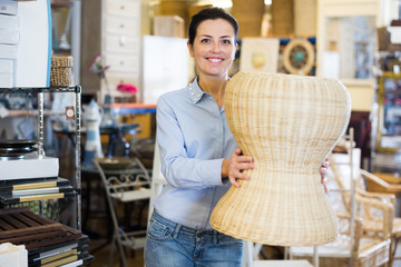 Smiling woman housewife choosing chair at  store