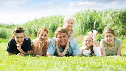 Fototapeta premium the large family lying on the grass in park.