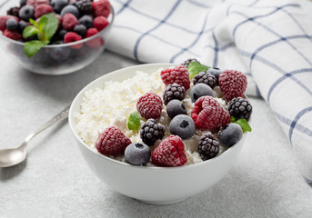 Cottage cheese with berries, honey and mint. Healthy breakfast cottage cheese with raspberries, blueberries and blackberries.