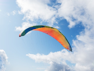 Paraglider flying on a background of blue sky and clouds. Clpseup