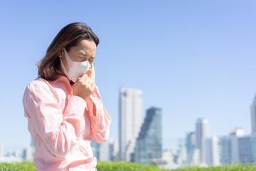 Fototapeta premium close up asian businesswoman wear mask to protect dust and virus while walking outdoor in the city for unhealthy life concept