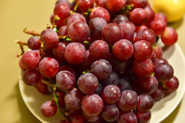 Ripe grape berries in a white plate
