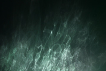 play of reflected scattered sunlight on a dark wall