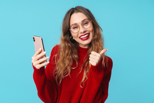Image of delighted nice woman using cellphone and showing thumb up