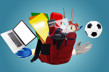 Backpack with school supplies laptop, isolated on blue