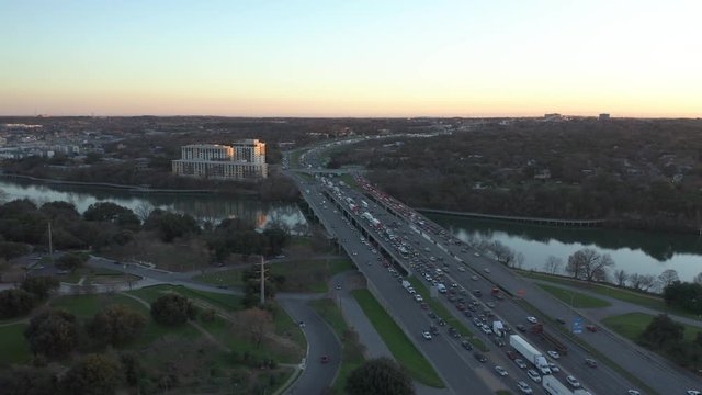 Aerial View of Heavy Highway Traffic on Bridge Crossing River at Sunset - Rush Hour Commute
