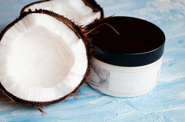  Coconut skin cream and two halves of coconut on a blue texture background