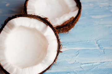  Two halves of coconut on a blue texture background
