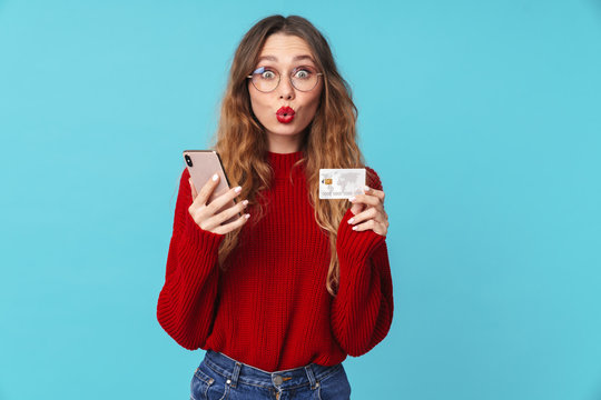 Image of amusing caucasian woman holding cellphone and credit card