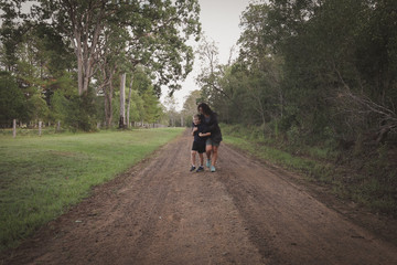 Fototapeta premium Mother and son walking together down country lane