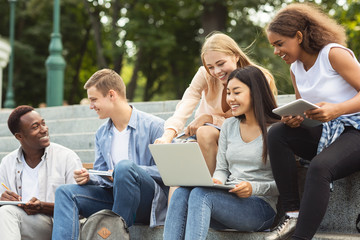 Group of positive students doing project together