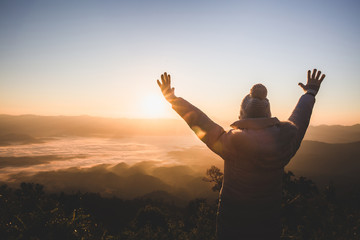 Women praying at sunset mountains raised hands Travel Lifestyle spiritual relaxation emotional...