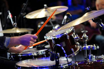 Musician hands holding drumsticks playing drums, marching cymbals