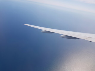 Flugreise: Flügel eines Passagierflugzeugs über dem Atlantik (Meer)