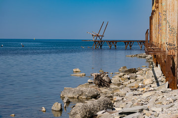 Very rusty metal frames, old thick metal subject to corrosion from salty seawater. Red bright color in sunlight