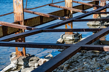 Very rusty metal frames, old thick metal subject to corrosion from salty seawater. Red bright color...