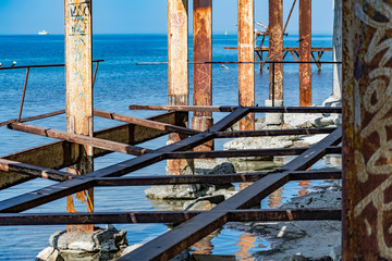 Fototapeta premium Very rusty metal frames, old thick metal subject to corrosion from salty seawater. Red bright color in sunlight