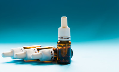 cosmetology, glass bottles with pipettes and cosmetic on a blue background