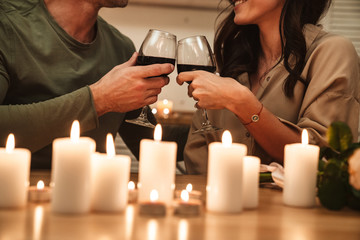 Image of couple drinking red wine while having romantic dinner at home