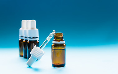 cosmetology, glass bottles with pipettes and cosmetic on a blue background