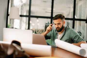 Focused architect working on project. Handsome businessman in office. 
