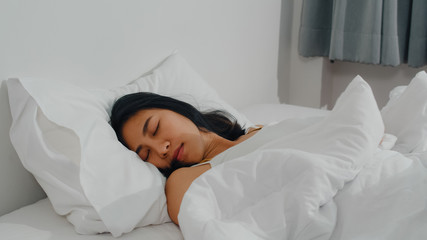 Obraz na płótnie Canvas Asian indian lady sleep in room at home. Young Asian girl feeling happy relax rest lying on bed, feel comfortable and calm in bedroom at house at the morning.