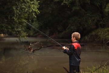 Young boy fresh water fishing in isolated river in New South Wales, Australia 