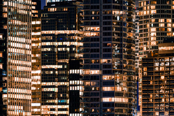 Facade windows of illuminated modern skyscraper with office building