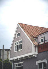 casa con tejado anaranjado en forma triangular con cielo nublado