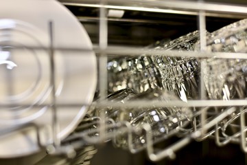 Pure utensils sparkle and shine on the top shelf of the dishwasher, view at an angle. 