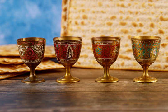 Four wine cups with matzah. Jewish holidays Passover.