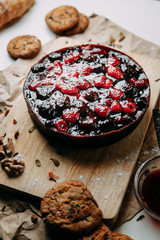 Cake on Kraft paper with cookies. Berry cake on a wooden Board. Raspberries and cherries in a pie.