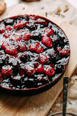 Cake on Kraft paper with cookies. Berry cake on a wooden Board. Raspberries and cherries in a pie.