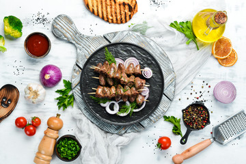Baked chicken heart on skewers in a black plate. Chicken meat. Top view. Free space for your text.