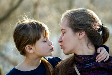 Young mom and her daughter girl together outdoors.