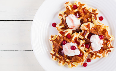 Traditional belgian waffles with berries, sour cream and jam on white wooden table. Top view, overhead