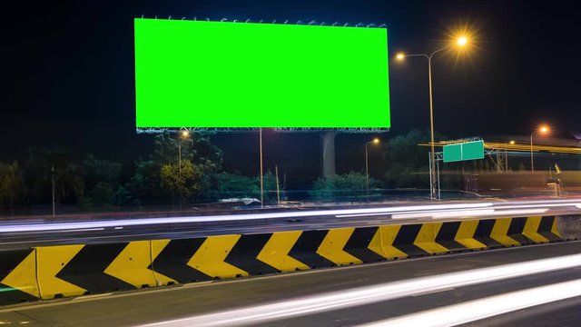 4k - Advertising billboard green screen on sidelines of expressway with traffic at evening, time lapse.