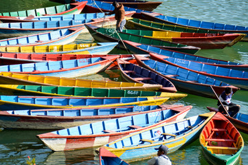 Fototapeta na wymiar Colorful traditional Nepalese wooden boats in the famous Fewa Lake in Pokhara, Nepal