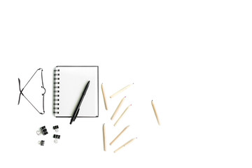 Working space with telephone, notebooks, pencils, flower and glasses on a white background. Top view, ftat lay